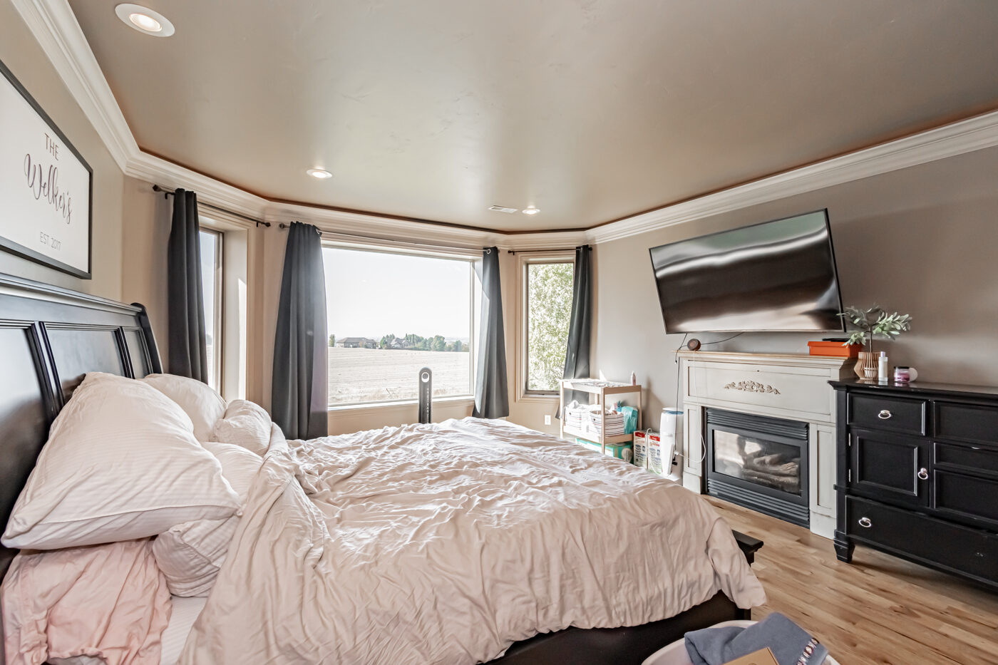 Primary bedroom with tray ceiling and fireplace